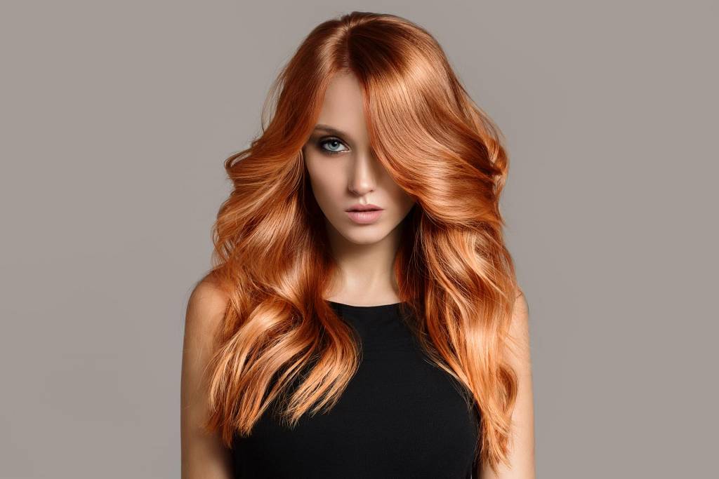 female-long-orange-hair-blue-eyes-light-feature-black-top-hair-covering-eye