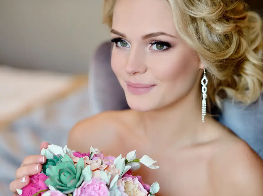 blonde-bride-smiling-hair-perfectly-styled-holding-flowers-ready-for-wedding-1920x1280